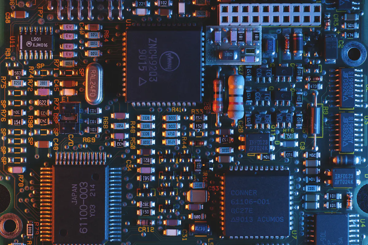 Macro photograph of a blue and orange printed circuit board.