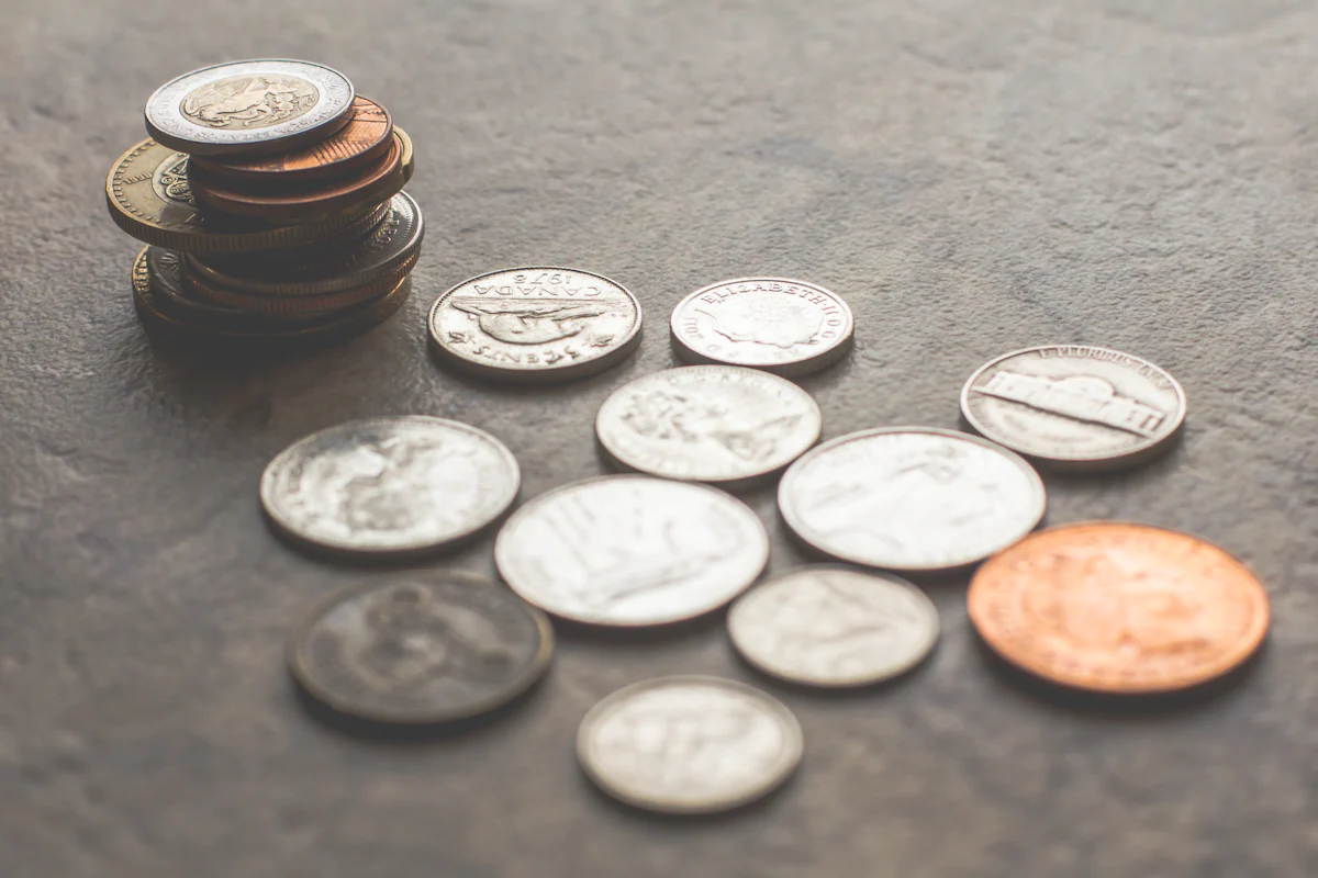 Assorted coins on a gray surface.
