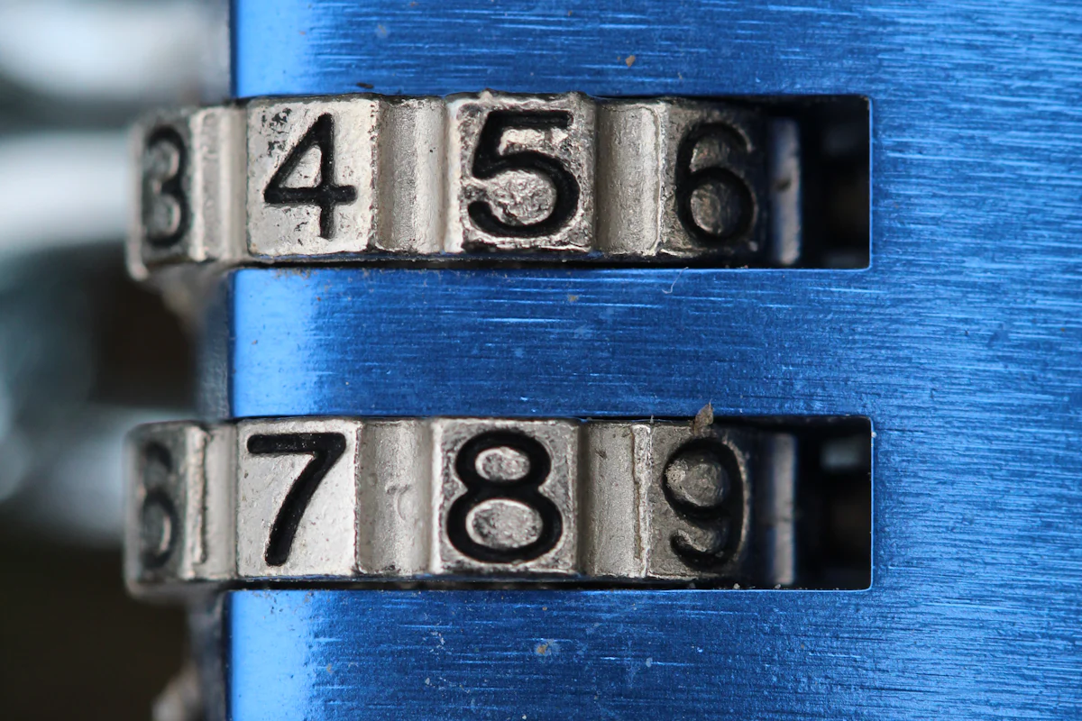 A close-up of numbered combination wheels on a blue metal padlock.